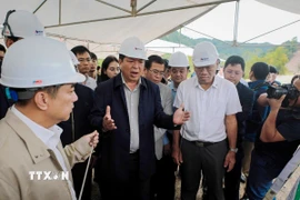 Bộ trưởng Bộ Xây dựng Trần Hồng Minh (đứng giữa) chỉ đạo tại công trình. (Ảnh: Diệp Anh/TTXVN)