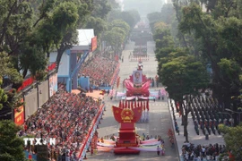 Lễ diễu binh bắt đầu với Đội hình xe mô hình Quốc huy nước Cộng hòa Xã hội Chủ nghĩa Việt Nam và xe rước chân dung Chủ tịch Hồ Chí Minh diễu qua Lễ đài. (Ảnh: TTXVN)