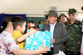 Thường trực Ban Bí thư Trần Cẩm Tú tặng quà, hỗ trợ nhân dân xã Diên Điền chịu hậu quả nặng nề do mưa lũ. (Ảnh: Phương Hoa/TTXVN)