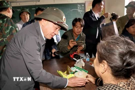 Thường trực Ban Bí thư Trần Cẩm Tú tặng quà hỗ trợ nhân dân xã Diên Điền ở nơi sơ tán. (Ảnh: Phương Hoa/TTXVN)