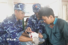 Tổ Quân y Hải đội 401 (Bộ Tư lệnh Vùng Cảnh sát biển 4) tiến hành sơ cứu cho nạn nhân. (Ảnh: TTXVN phát)