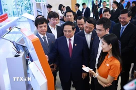 Thủ tướng Phạm Minh Chính tham quan trưng bày về phát triển khoa học, công nghệ, đổi mới sáng tạo và chuyển đổi số. (Ảnh: Dương Giang/TTXVN)