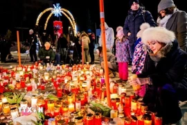 Người dân thắp nến tưởng nhớ những nạn nhân trong vụ cháy quán bar Le Constellation. (Ảnh: TTXVN phát)