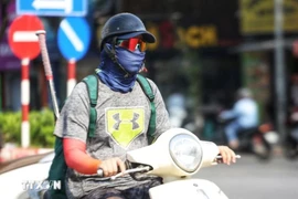 Người dân bịt kín khi ra đường trong ngày nắng nóng. (Ảnh: Thu Phương/TTXVN phát)