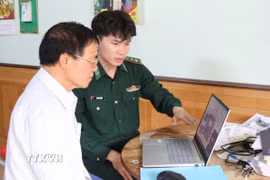 Cán bộ Đồn Biên phòng cửa khẩu Chi Ma, tỉnh Lạng Sơn, chỉ dẫn người dân nhận biết các website thông tin chính thống. (Ảnh: Quang Duy/TTXVN)