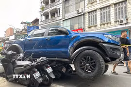 Ôtô tông liên hoàn nhiều xe máy tại phố Khâm Thiên. (Ảnh: Huy Hùng/TTXVN)