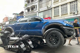 Ôtô tông liên hoàn nhiều xe máy tại phố Khâm Thiên. (Ảnh: Huy Hùng/TTXVN)