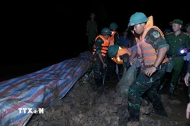 Các lực lượng đắp đê chống tràn, bảo đảm an toàn tuyến đê hữu Cầu. (Ảnh: Dương Giang/TTXVN)