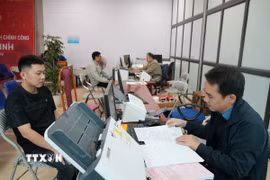 Cán bộ xã Tân Minh giải quyết thủ tục cho người dân. (Ảnh Tiến Vĩnh/TTXVN)