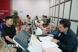 Cán bộ xã Tân Minh giải quyết thủ tục cho người dân. (Ảnh Tiến Vĩnh/TTXVN)