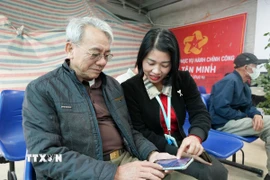 Người cao tuổi được hướng dẫn cài đặt ứng dụng Zalo Mini App tại xã Tân Minh. (Ảnh Tiến Vĩnh/TTXVN)