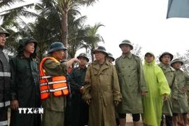 Phó Thủ tướng Trần Hồng Hà nghe báo cáo về tình hình xâm thực, xói lở bờ biển An Bàng. (Ảnh: Anh Dũng/TTXVN)