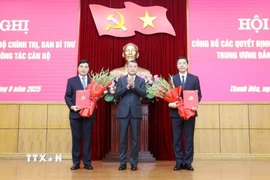 Đồng chí Lê Minh Hưng, Ủy viên Bộ Chính trị, Bí thư Trung ương Đảng, Trưởng Ban Tổ chức Trung ương trao quyết định của Bộ Chính trị cho đồng chí Nguyễn Hoài Anh (trái) và đồng chí Nguyễn Hồng Phong (phải). (Ảnh: Việt Hoàng/TTXVN)
