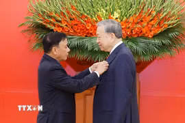 Đồng chí Trần Cẩm Tú, Ủy viên Bộ Chính trị, Thường trực Ban Bí thư trao Huy hiệu Đảng và tặng hoa chúc mừng Tổng Bí thư Tô Lâm. (Ảnh: Thống Nhất/TTXVN)