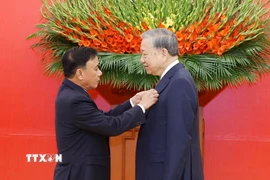 Đồng chí Trần Cẩm Tú, Ủy viên Bộ Chính trị, Thường trực Ban Bí thư trao Huy hiệu Đảng và tặng hoa chúc mừng Tổng Bí thư Tô Lâm. (Ảnh: Thống Nhất/TTXVN)
