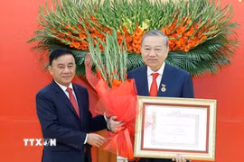Đồng chí Trần Cẩm Tú, Ủy viên Bộ Chính trị, Thường trực Ban Bí thư trao Huy hiệu Đảng và tặng hoa chúc mừng Tổng Bí thư Tô Lâm. (Ảnh: Thống Nhất/TTXVN)