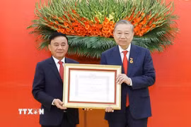 Đồng chí Trần Cẩm Tú, Ủy viên Bộ Chính trị, Thường trực Ban Bí thư trao Huy hiệu Đảng và chúc mừng Tổng Bí thư Tô Lâm. (Ảnh: Thống Nhất/TTXVN)