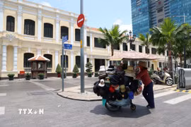 Một chiếc xe bán đồ chống nắng trên góc đường Nguyễn Huệ-Lê Thánh Tôn, phường Bến Nghé. (Ảnh: Hồng Đạt/TTXVN)