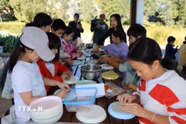 Các em nhỏ thực hành gói nem - món ăn đậm bản sắc Việt. (Ảnh: Thanh Tú/TTXVN)