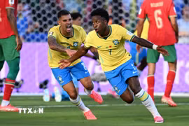 Tiền đạo Vinicius Junior (phải) ăn mừng bàn thắng gỡ hòa 1-1 cho đội nhà trước tuyển Maroc. (Ảnh: AFP/TTXVN)