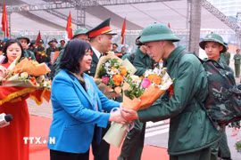 Bí thư Thành ủy Hà Nội Bùi Thị Minh Hoài tặng hoa, động viên và tiễn tân binh Quận Ba Đình lên đường nhập ngũ. (Ảnh: Văn Điệp/TTXVN)