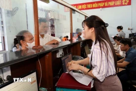 Cán bộ Trung tâm phục vụ hành chính công xã Hoàn Lão (tỉnh Quảng Trị) giải đáp các thắc mắc cho người dân trong giải quyết thủ tục hành chính. (Ảnh: Tá Chuyên/TTXVN)