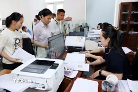 Cán bộ Trung tâm dịch vụ hành chính công phường Đồng Hới (Quảng Trị) giải quyết thủ tục hành chính cho người dân địa phương. (Ảnh: Tá Chuyên/TTXVN)