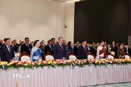 Tổng Bí thư Tô Lâm và Phu nhân, Tổng Bí thư Ban Chấp hành Trung ương Đảng Nhân dân Cách mạng Lào, Chủ tịch nước Cộng hòa Dân chủ Nhân dân Lào Thongloun Sisoulith và Phu nhân cùng các đại biểu thực hiện nghi lễ chào cờ. (Ảnh: Thống Nhất/TTXVN)