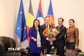 Đại sứ Nguyễn Văn Thảo và phu nhân tặng hoa chúc mừng Đại sứ Lào Kingphokeo Phommahaxay và phu nhân. (Ảnh: Hương Giang/TTXVN)