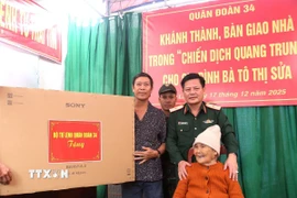 Thiếu tướng Nguyễn Trần Long, Ủy viên Ban Thường vụ Đảng uỷ, Phó Chính ủy Quân đoàn 34, trao tặng quà cho hộ gia đình bà Tô Thị Sửa. (Ảnh: Quang Thái/TTXVN)