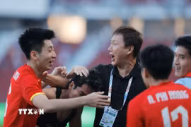 Thầy trò HLV Kim Sang Sik vỡ òa cảm xúc khi giành vé vào chung kết SEA Games 33. (Ảnh: Minh Quyết/TTXVN)