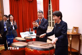 Thủ tướng Nhật Bản Takaichi Sanae trải nghiệm đánh trống - sản phẩm âm nhạc truyền thống của Việt Nam. (Ảnh: Dương Giang/TTXVN)