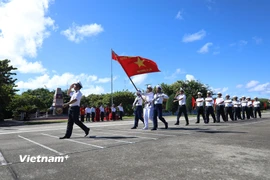 Đi đầu là đội danh dự với Quân kỳ Quyết thắng qua lễ đài trước cờ Tổ quốc và cột mốc chủ quyền đảo Trường Sa. (Ảnh: Huy Khánh/Vietnam+)