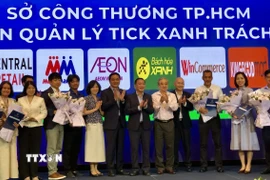 Đại diện Sở Công thương Thành phố Hồ Chí Minh thực hiện nghi thức trao quyền kiểm soát sản phẩm Tick xanh trách nhiệm cho 11 hệ thống phân phối. (Ảnh: Mỹ Phương/TTXVN)