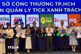 Đại diện Sở Công thương Thành phố Hồ Chí Minh thực hiện nghi thức trao quyền kiểm soát sản phẩm Tick xanh trách nhiệm cho 11 hệ thống phân phối. (Ảnh: Mỹ Phương/TTXVN)