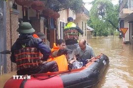 Công an thành phố Huế hỗ trợ, di dời người dân phường An Cựu ra khỏi vùng ngập lụt. (Ảnh: TTXVN phát)