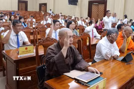 Đại biểu HĐND tỉnh Kiên Giang biểu quyết thông qua các nghị quyết. (Ảnh: Lê Huy Hải/TTXVN)