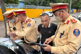 CSGT cung cấp hình ảnh chứng minh lỗi vi phạm dừng đón trả khách sai quy định cho tài xế xe khách. (Ảnh: Phạm Kiên/TTXVN)