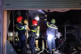 Lực lượng phòng cháy chữa cháy dập tắt đám cháy tại cửa hàng phụ tùng xe máy điện. (Nguồn: Báo Bắc Giang)