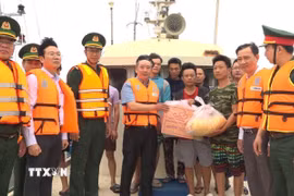 Phó Chủ tịch UBND thành phố Hải Phòng Trần Văn Quân, tặng quà cho ngư dân nước ngoài bị nạn đang neo đậu tại âu cảng Bạch Long Vĩ. (Ảnh: TTXVN phát)