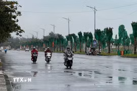 Người dân di chuyển dưới cơn mưa . (Ảnh: Hoàng Nhị/TTXVN)