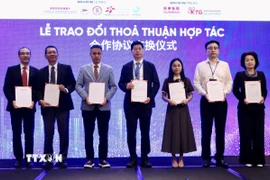 Đại diện doanh nghiệp Việt Nam và Trung Quốc trao đổi thoả thuận hợp tác tại diễn đàn. (Ảnh: Xuân Anh/TTXVN)