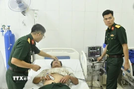Các bác sỹ quân y tại Bệnh xá đảo Nam Yết thăm khám cho bệnh nhân Đoàn Tính. (Ảnh: TTXVN phát)