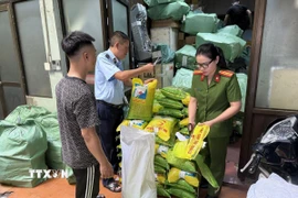 Lực lượng chức năng kiểm tra số gạo vi phạm. (Ảnh: TTXVN phát)