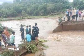 Cây cầu bị cuốn trôi hoàn toàn một đoạn dài khoảng 15m. (Ảnh: TTXVN phát)