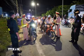 Lực lượng Phòng Cảnh sát Giao thông kiểm tra nồng độ cồn. (Ảnh: Giang Phương/TTXVN)