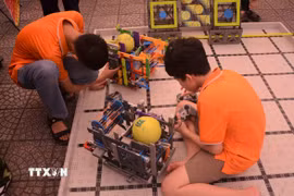 Học sinh khám phá các robot gắp bóng tại ngày hội STEM. (Ảnh: Văn Dũng/TTXVN)