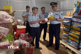 Công chức Đội Quản lý thị trường số 1 phối hợp kiểm tra hàng hóa vi phạm. (Ảnh: TTXVN phát)
