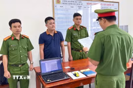 Cơ quan Cảnh sát điều tra tống đạt quyết định khởi tố bị can Huỳnh Đức Đạt. (Ảnh: Trọng Nguyễn/TTXVN phát)