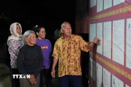 Đồng bào Công giáo thôn Plei Klêch, xã Ngọk Bay, tỉnh Quảng Ngãi, theo dõi thông tin đại biểu ứng cử. (Ảnh: Dư Toán/TTXVN)